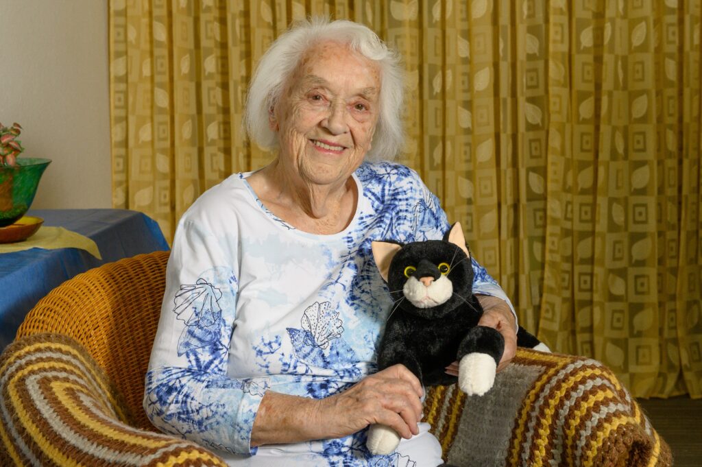 "Seniorin interagiert mit einem sensorischen Hilfsmittel zur Demenztherapie."